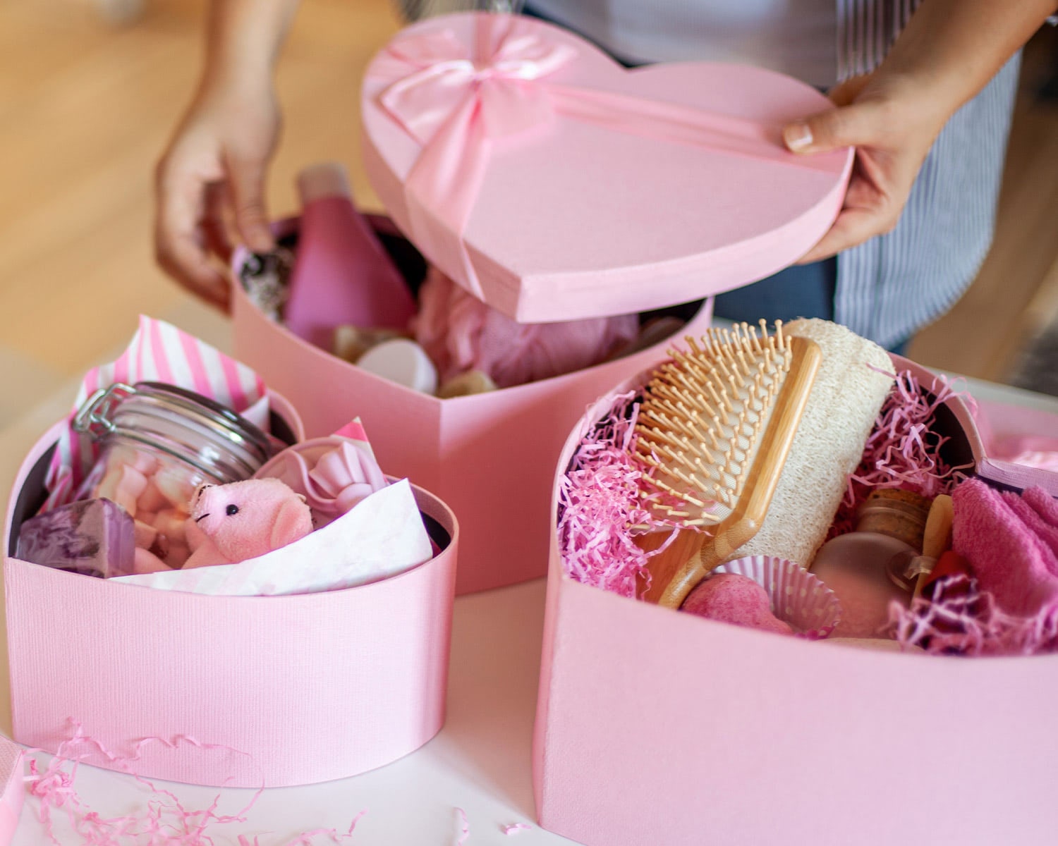 Pink Galentineâ€™s gift boxes filled with spa items and sweet treats, arranged for Galentineâ€™s celebrations