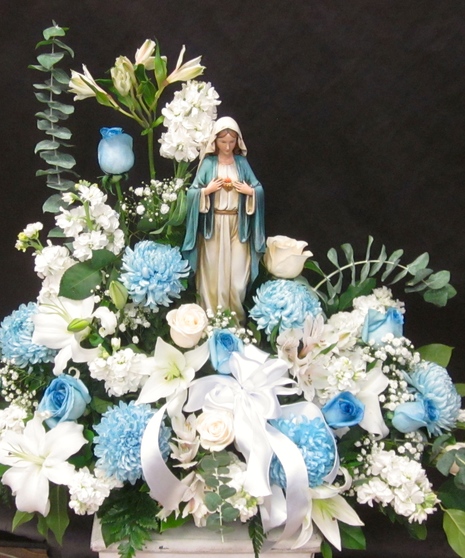 Blue and white flowers surrounding a keepsake Madonna statue