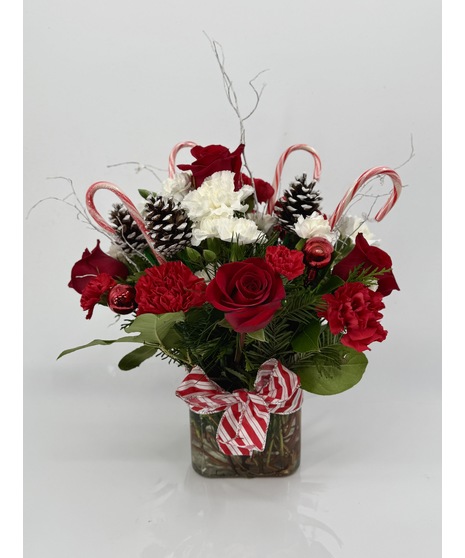 Cube vase of red and white flowers, winter greenery and candy canes