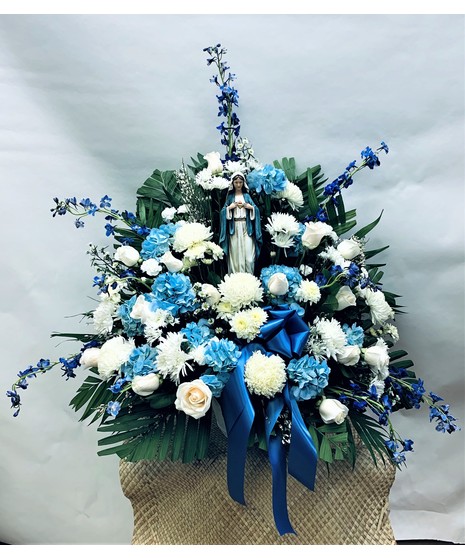 Blue and white flowers surrounding a keepsake Madonna statue