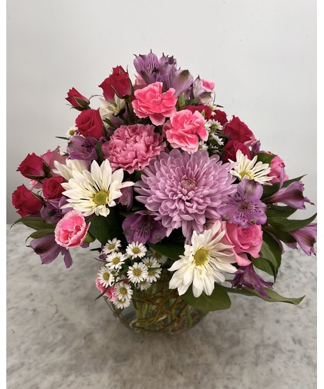 Bubble bowl filled with pink, purple and white daisies, carnations and alstroemeria