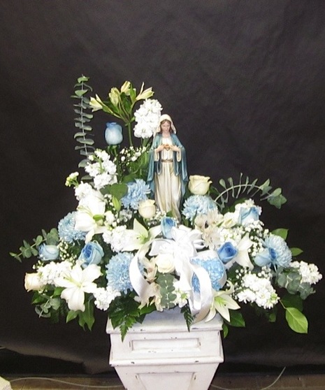 Blue and white flowers surrounding a keepsake Madonna statue