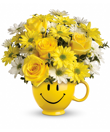 Smiley face mug full of roses and daisies.