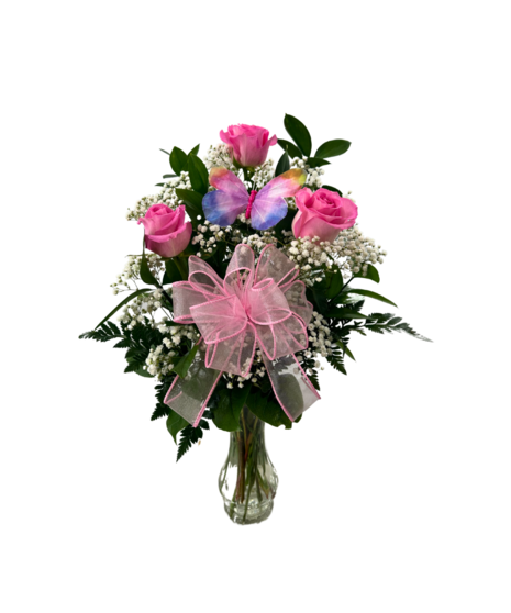 three roses in a vase with accent greenery and ribbon