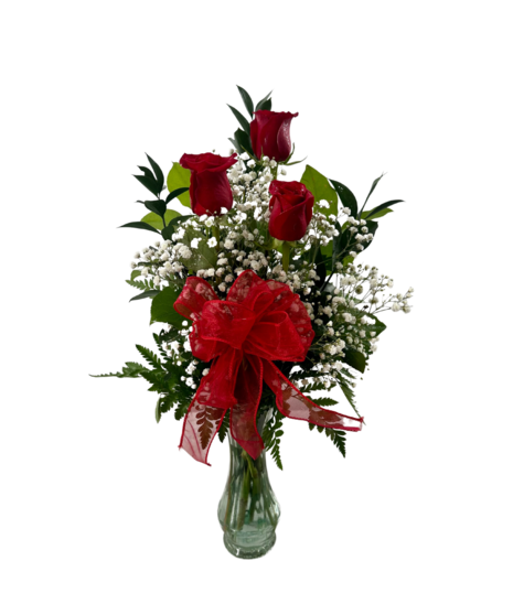 three roses in a vase with accent greenery and ribbon