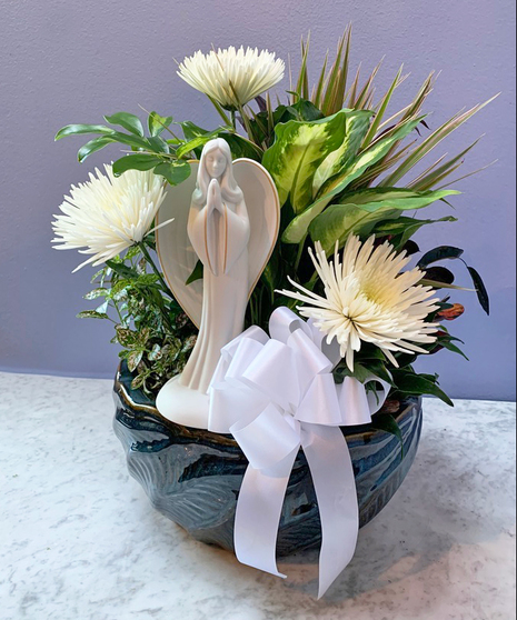 Dish garden of green and blooming plants with a keepsake angel statue for the home or garden.