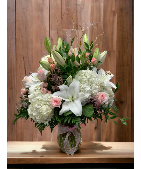 white floral arrangement accented with pink spray roses